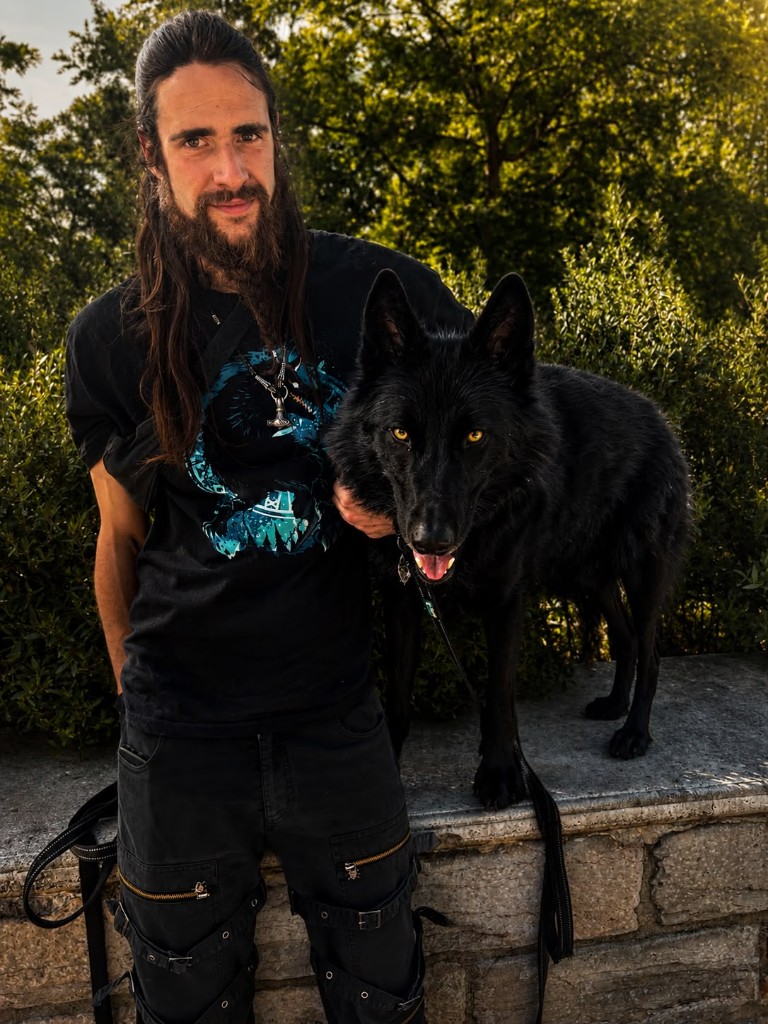 Gabriel et Fenrir posent côte à côte devant un massif de verdure.